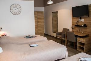 奥西耶克Rooms Rebolj的酒店客房设有两张床、一张桌子和一台电视。