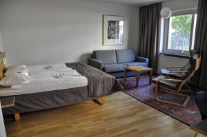 龙讷比Ronneby Cityhotell的一间卧室配有一张床、一张沙发和一把椅子
