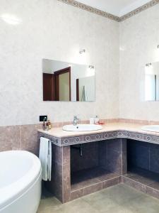 卡利亚里Rosa's House - zona ospedaliera的浴室设有2个水槽、浴缸和镜子