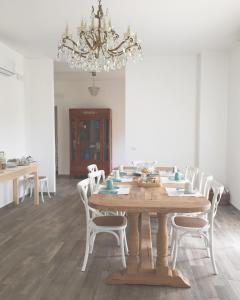 阿布鲁齐的罗塞托Il Gelsomino的一间带木桌和白色椅子的用餐室