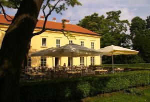 雷德尼斯扎莫奇莱德尼斯酒店的前面有桌子和遮阳伞的黄色建筑