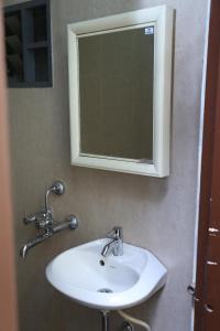 那格浦尔Shivam Apartment的浴室设有白色水槽和镜子