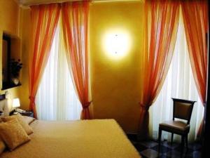 蒙特罗索阿尔马雷诗歌作家酒店的一间卧室设有床、两扇窗户和一把椅子