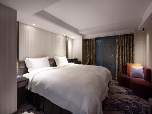 台北在家行旅 西門館的卧室配有一张白色大床和一张红色沙发