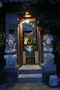 乌布Pondok Penestanan Villa Ubud的两座石头雕像房子的入口