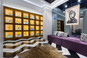 哈尔科夫米拉克斯蓝宝石精品酒店的一间设有紫色沙发和玻璃墙的客房