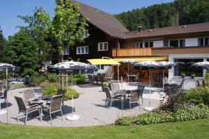 Bühler兰格福斯恩酒店的一个带桌椅和遮阳伞的庭院