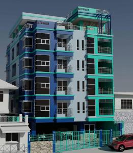 碧瑶菲迪欧斯凯兰兹公寓的一座蓝色和白色的建筑,前面有停车位