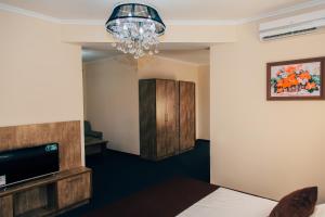 撒马尔罕撒马尔罕贝克酒店的酒店客房,配有一张床和吊灯