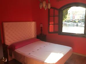 珀特萨普拉亚Port Saplaya - Vistas al mar的红色房间的一个床位,窗户