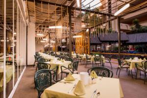 卡门港比亚特丽斯海滩Spa酒店的餐厅设有白色的桌椅和天花板。