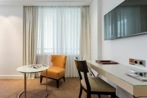 巴黎卡斯蒂尼奥那酒店的客房设有书桌、椅子和桌子。