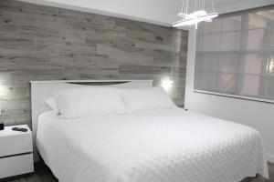阿文图纳Yacht Club at Aventura Luxurious 1 Bed 1 Bath的卧室配有白色的床和木墙