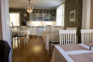 诺拉Lilla Hotellet i Nora的一间带桌椅的用餐室和一间厨房