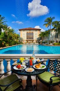 迈阿密Biltmore Hotel Miami Coral Gables的桌边的餐桌,旁边放着盘子