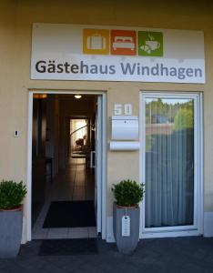 温德哈根Gästehaus Windhagen的带有读取花纹风车标志的建筑