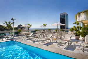 里约热内卢温莎广场科帕卡巴纳酒店的一个带桌椅的游泳池和一个游泳池
