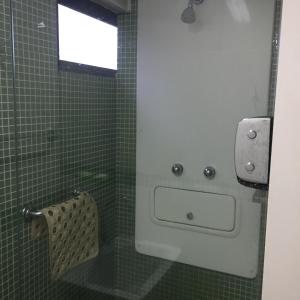 累西腓博阿维亚任公寓的绿色瓷砖浴室设有水槽和窗户