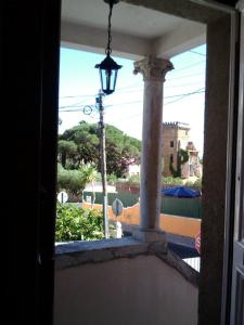 埃斯托利尔Villa Charme的阳台的窗户享有街景,配有街灯