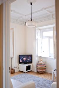 埃斯托利尔Villa Charme的一间配备有电视和窗户的白色客厅