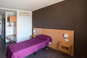 马德里Hostal Mediterranea的一间卧室配有一张紫色的床和一张桌子