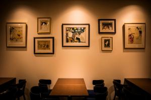 东京相铁Fresa Inn银座七丁目酒店的一间用餐室,配有一张桌子和墙上的照片
