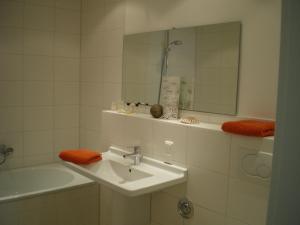 瓦尔内明德Ferienwohnung Nr.31的浴室配有盥洗盆、镜子和浴缸