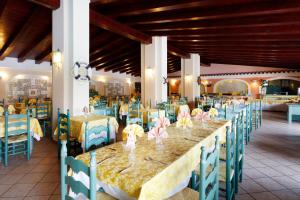 卡拉·利贝罗托Alba Dorata Resort的一间用餐室,配有一张长桌子和蓝色的椅子