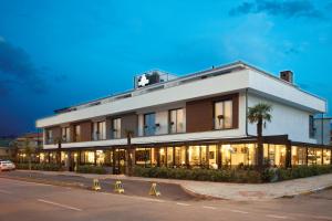 代尼兹利卡萨边卡酒店的一座白色的建筑,前面有棕榈树