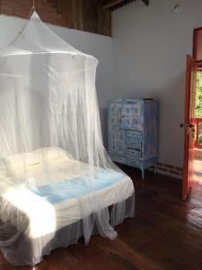 米卡Finca San Rafael - Cafe y Cacao的一间卧室配有一张带天蓬和梳妆台的床