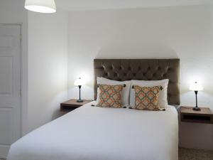 危地马拉In & Out Hotel的一间卧室配有一张带两盏灯的大型白色床。