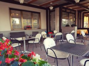 佩斯基耶拉德加达贝尔世都酒店的空荡荡荡的餐厅,配有桌椅和鲜花