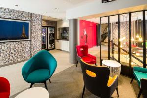 巴黎巴黎伏吉拉尔酒店的一间设有五颜六色的椅子和桌子的等候室