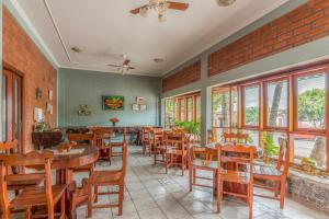 博尼图Pousada Rancho Jarinu的餐厅设有木桌、椅子和窗户。