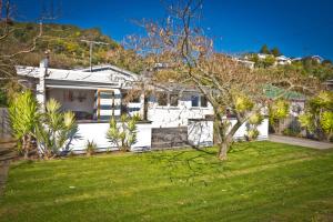 皮克顿3 & 4 Bedroom Holiday Houses Central Picton的白色的房子,有绿草的院子