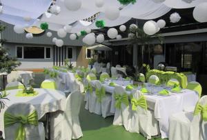 马尼拉企业酒店的一间设有白色桌椅和绿色弓形的房间