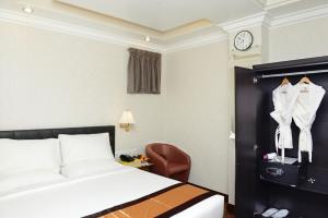仰光邦德酒店的酒店客房,配有床、椅子和时钟