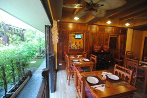 曼谷佛卡尔本地住宿加早餐酒店的用餐室配有木桌和椅子