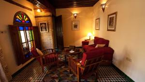 非斯利亚德萨拉马住宿加早餐旅馆的客厅配有红色的沙发和桌子