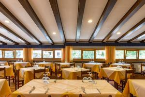 菲乌马尔博Hotel Appennino的用餐室配有带黄桌布的桌子