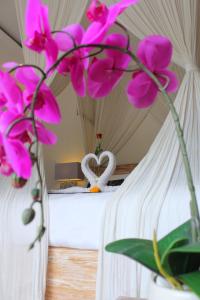 乌布乌玛别墅酒店的一间房间,床上有粉红色的鲜花