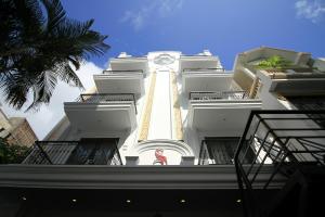 顺化斯嘉丽精品酒店的一座高大的白色建筑,上面有时钟