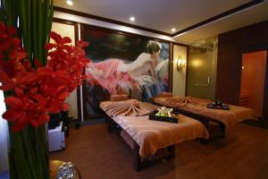 顺化斯嘉丽精品酒店的一间设有三张床的客房,墙上挂着一幅画