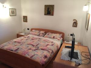 科雷多A Casa di Rita的一间卧室配有一张床和一张书桌及电视