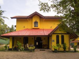 UggalbodaResort Like No Other的黄色的房屋,有红色的屋顶