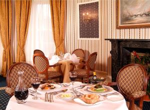 巴森斯韦特水上会馆酒店的用餐室配有餐桌和食物