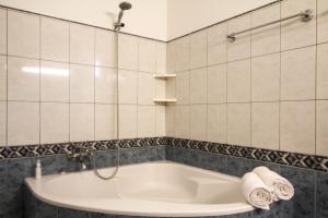 Madalena do MarSunset Sea Breeze的浴室铺有白色瓷砖,配有浴缸。