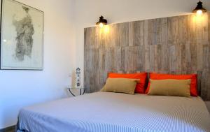 康特港B&B La Casa Bianca di Porto Conte的卧室配有带橙色枕头的大型白色床