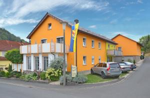 RamsthalGästehaus Ingrid的一座黄色的房子,前面有一辆汽车