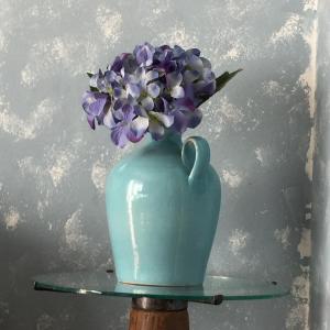 Sornico拉德贡达度假屋的一张桌子上布满紫色花的蓝色花瓶
